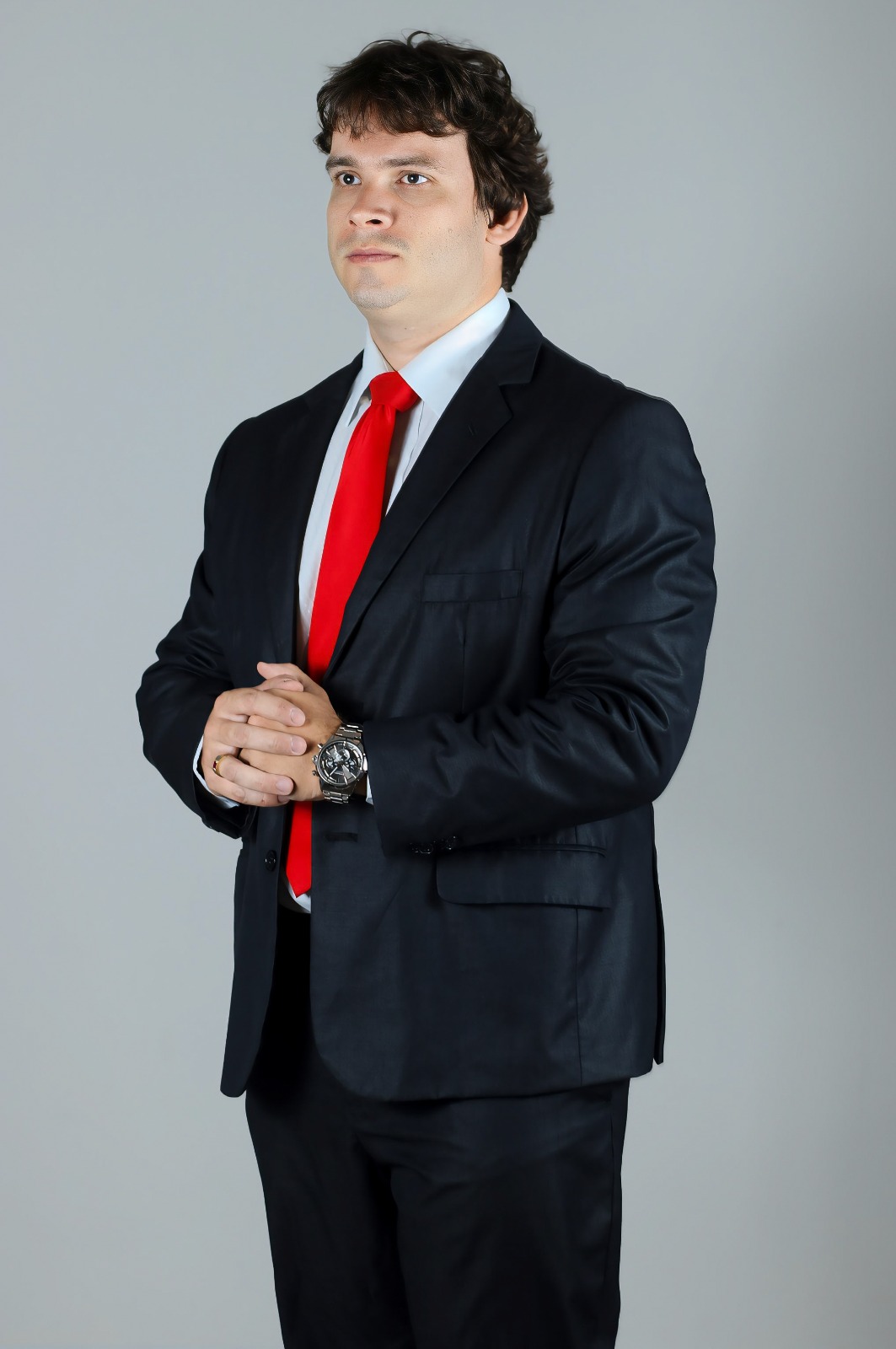 Dr. Alexandre Moreira Puchetti em pose institucional, usando terno escuro e gravata vermelha.